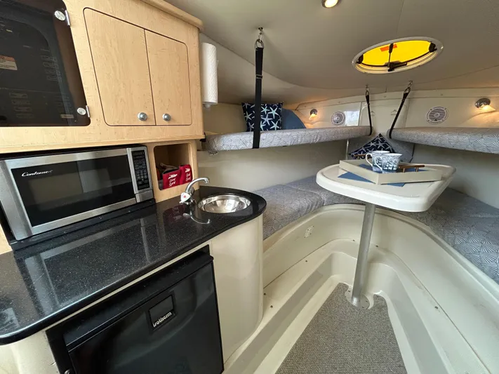 Good Sport Yacht Photos Pics 2011 Hydra-Sports 3000 VX cabin interior with kitchenette, microwave, and cozy sleeping area.