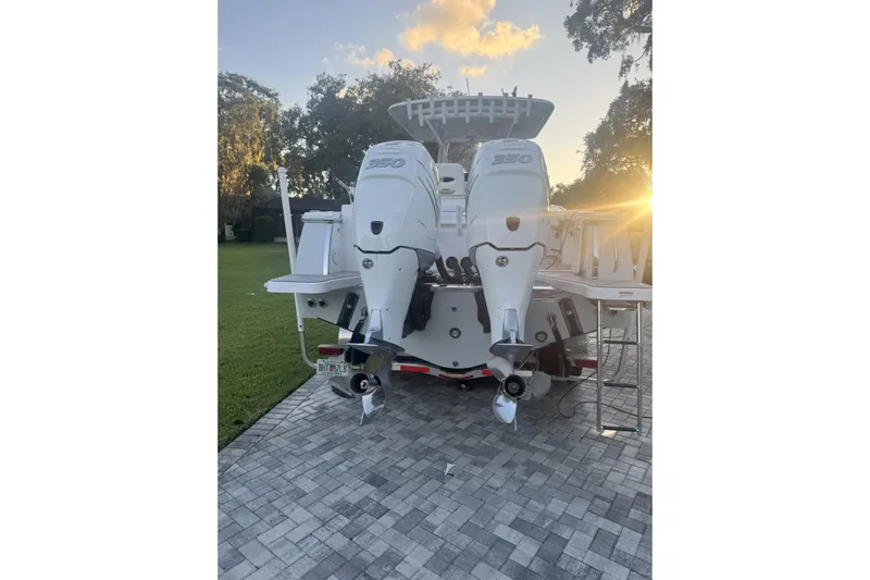  Yacht Photos Pics 2023 Southport 30 FE boat with dual 350 engines, parked on a paved driveway at sunset.
