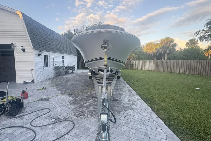  Yacht Photos Pics 2023 Southport 30 FE boat on trailer in driveway near garage and lawn.