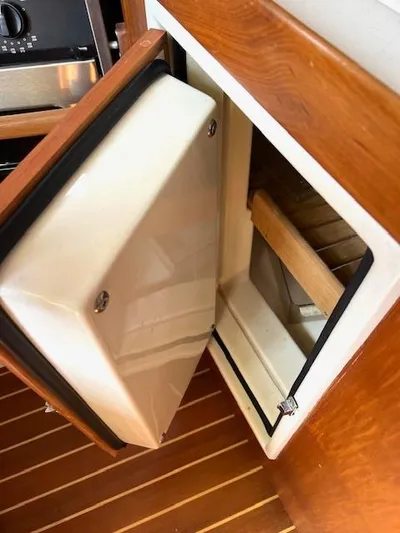 Force 10 Yacht Photos Pics Open refrigerator door on a 2008 Tartan 3400 yacht, showcasing wooden interior details.