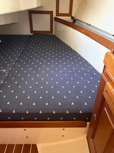 Force 10 Yacht Photos Pics Cabin interior of 2008 Tartan 3400 sailboat with patterned bedding and wooden accents.