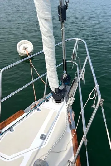 Force 10 Yacht Photos Pics Bow of 2008 Tartan 3400 sailboat with furled sail and calm water.