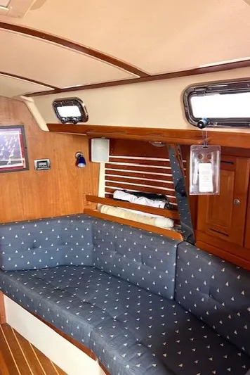 Force 10 Yacht Photos Pics Interior of 2008 Tartan 3400 sailboat with blue cushioned seating and wooden accents.