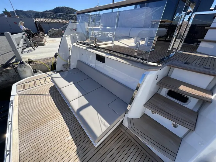  Yacht Photos Pics 2023 Prestige X60 yacht deck with seating and stairs, featuring sleek design and wood finish.