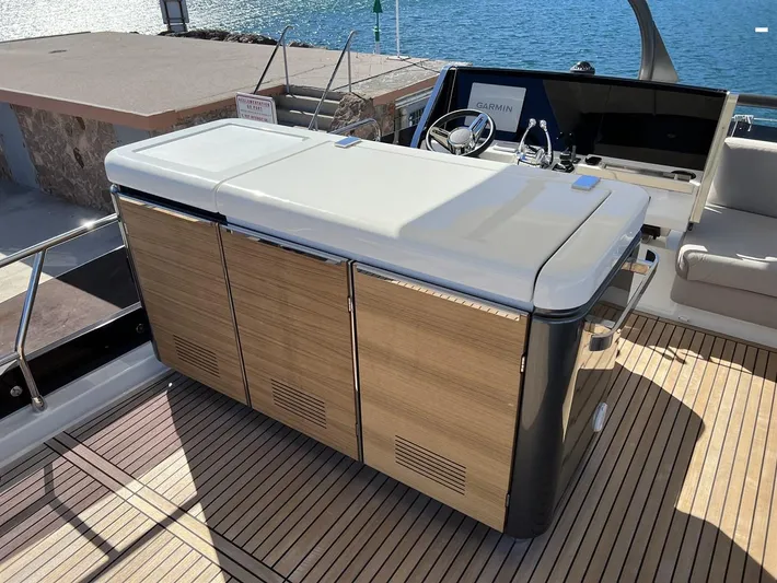  Yacht Photos Pics Luxury yacht deck with modern cabinetry, Prestige X60 2023 model, overlooking serene water.