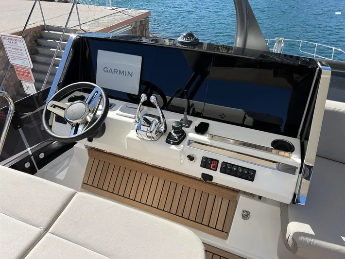  Yacht Photos Pics 2023 Prestige X60 yacht helm with Garmin navigation, sleek controls, and wooden accents by the sea.