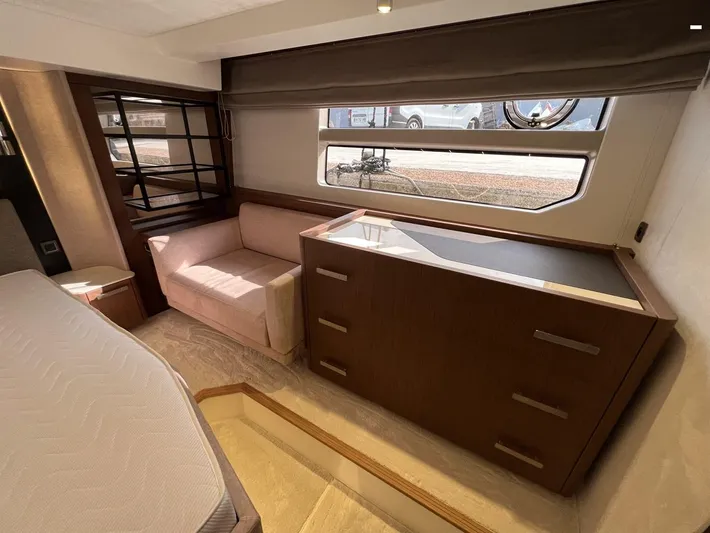 Yacht Photos Pics Luxurious interior of 2023 Prestige X60 yacht with sofa, window, and wooden cabinetry.