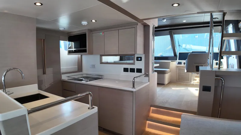  Yacht Photos Pics Modern interior of 2024 Gulf Craft Nomad 65 yacht, featuring sleek kitchen and helm area.