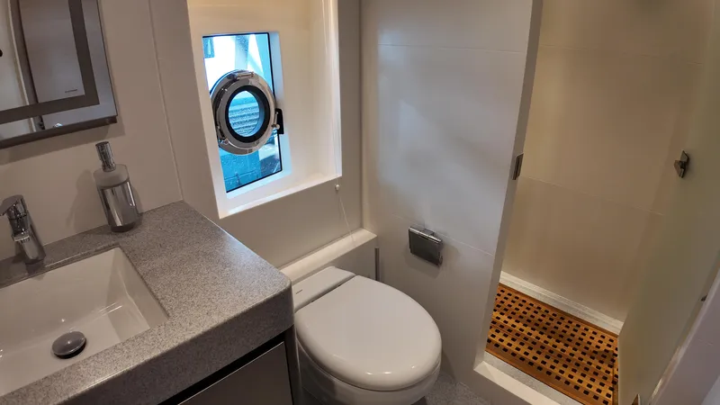  Yacht Photos Pics 2024 Gulf Craft Nomad 65 yacht bathroom with modern fixtures and porthole window.