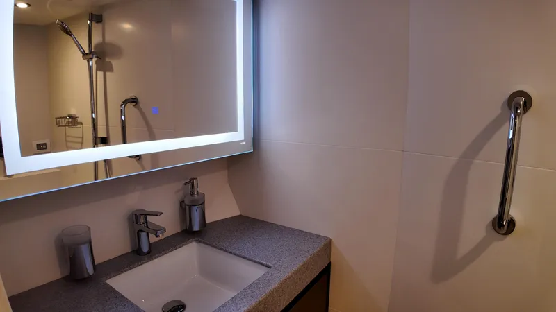  Yacht Photos Pics Modern bathroom interior on 2024 Gulf Craft Nomad 65 yacht, featuring sleek sink and illuminated mirror.