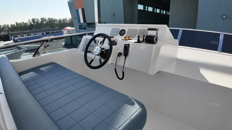  Yacht Photos Pics 2024 Gulf Craft Nomad 65 yacht helm with modern controls and blue cushioned seating.