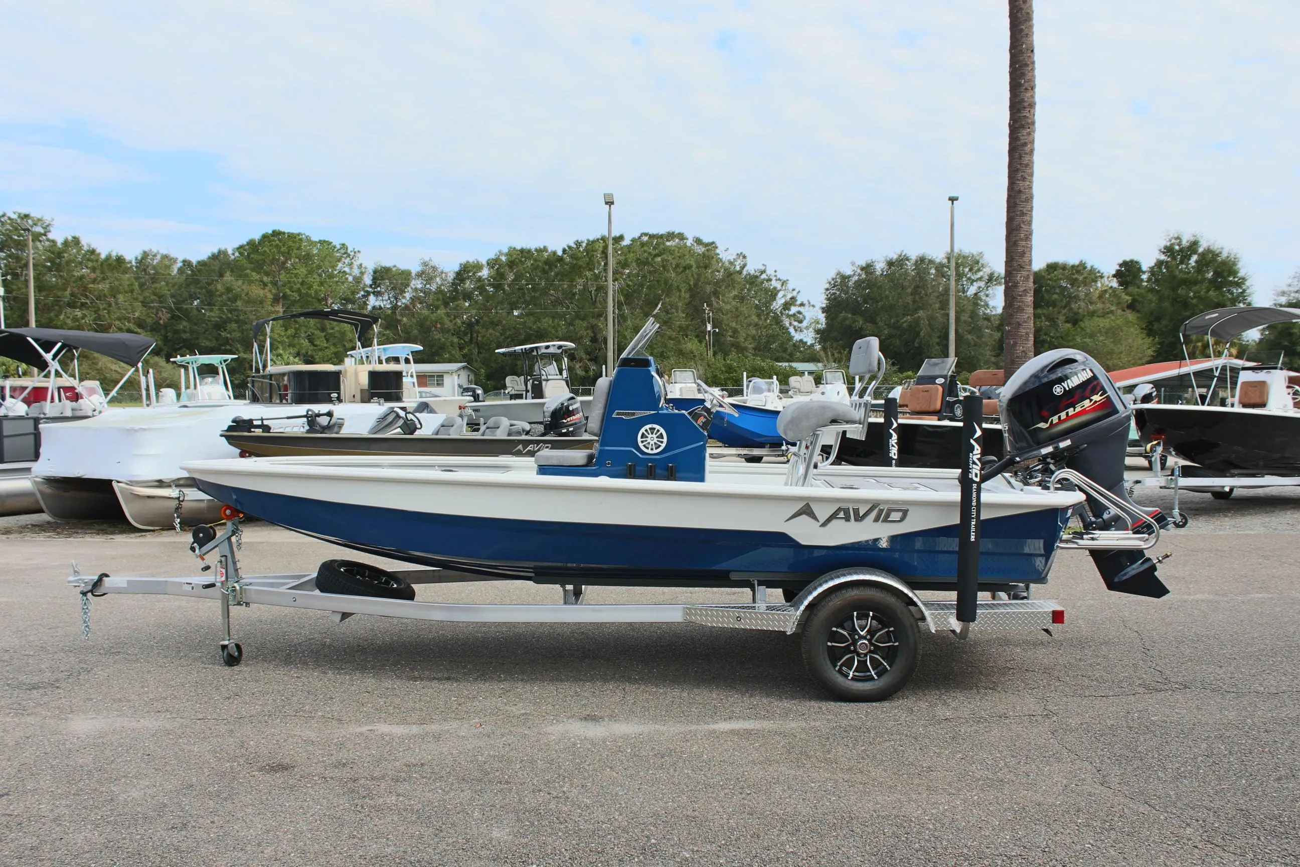 2025 Avid 19 FSX boat on trailer, parked outdoors with other boats in the background.