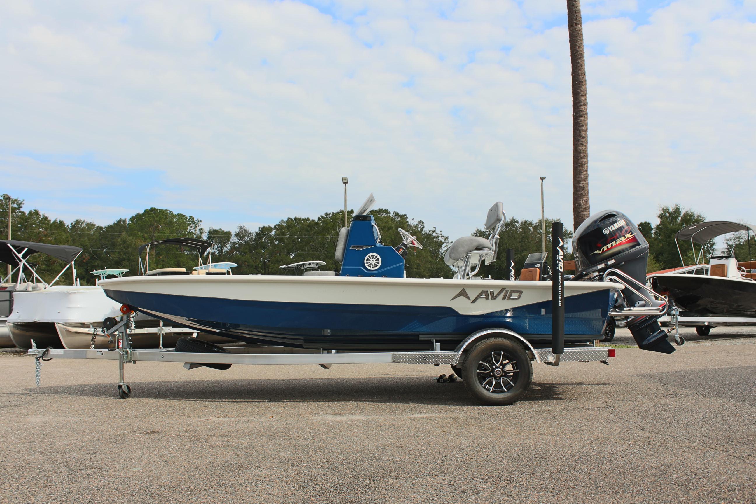 2025 Avid 19 FSX boat on trailer, parked outdoors, side view.