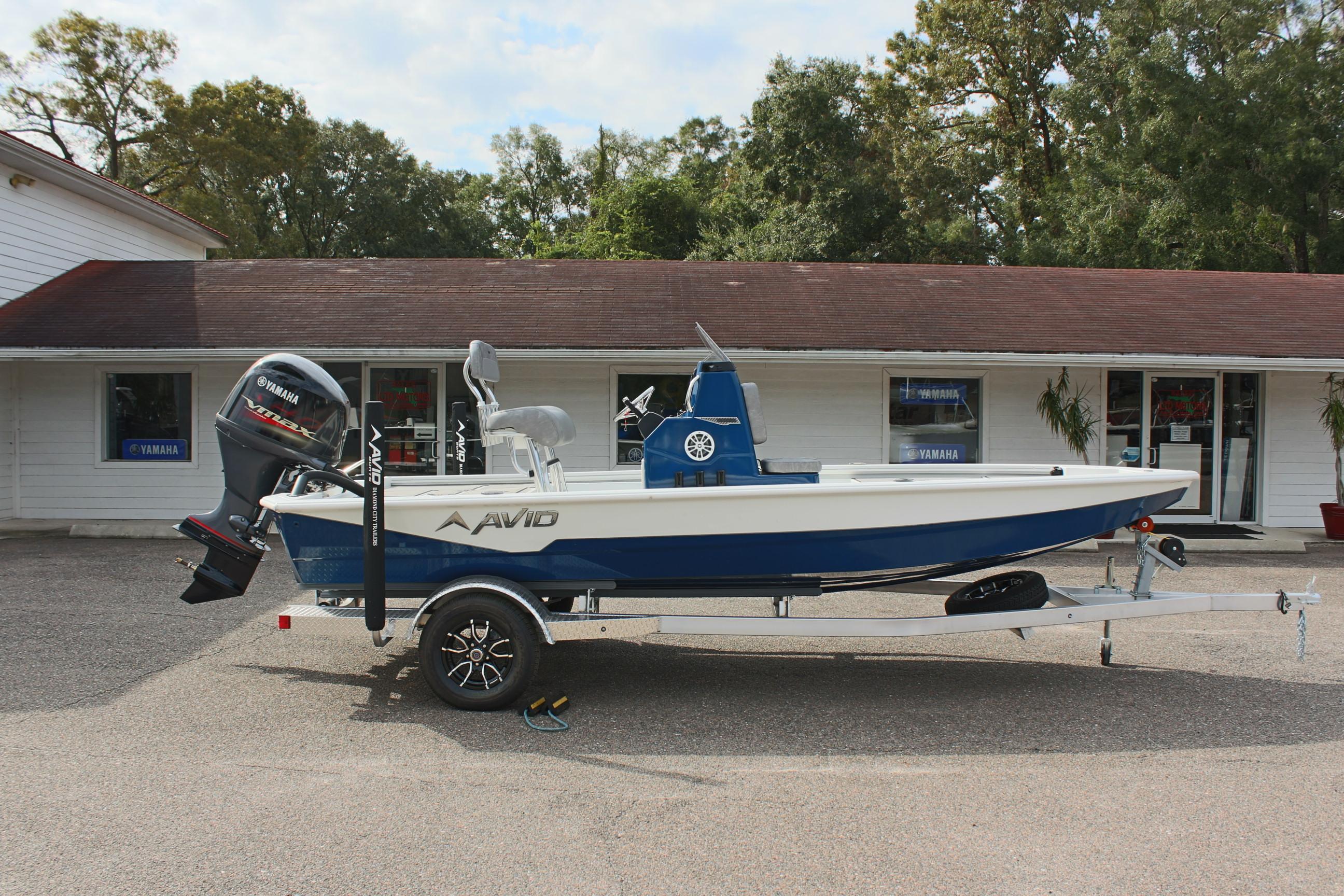 2025 Avid 19 FSX boat on trailer, parked outside a building.