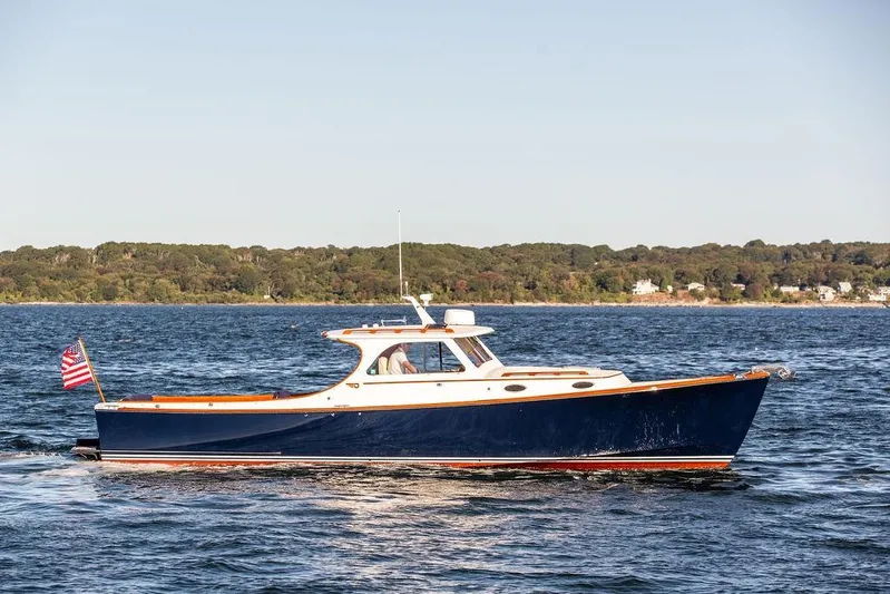 Hobnob Yacht Photos Pics 2001 Hinckley Yachts Picnic Boat Classic 36 cruising on open water, with scenic shoreline backdrop.
