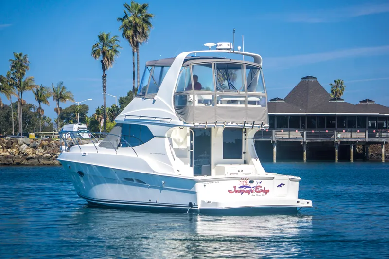 Journeys Edge Yacht Photos Pics 2007 Silverton 36 Convertible yacht on water near a dock with palm trees.