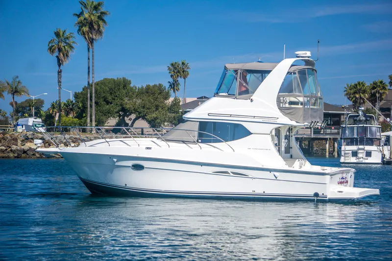 Journeys Edge Yacht Photos Pics 2007 Silverton 36 Convertible yacht on calm water with palm trees in the background.