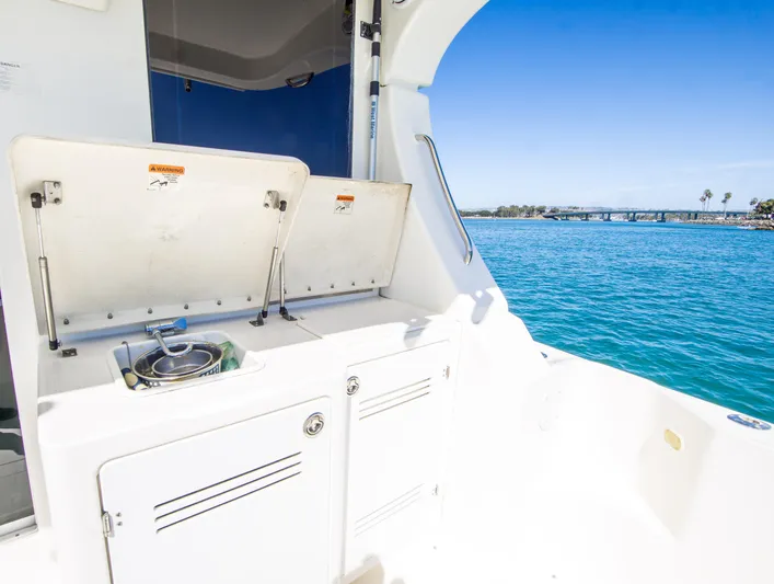 Journeys Edge Yacht Photos Pics 2007 Silverton 36 Convertible boat with open storage compartments, overlooking clear blue water.