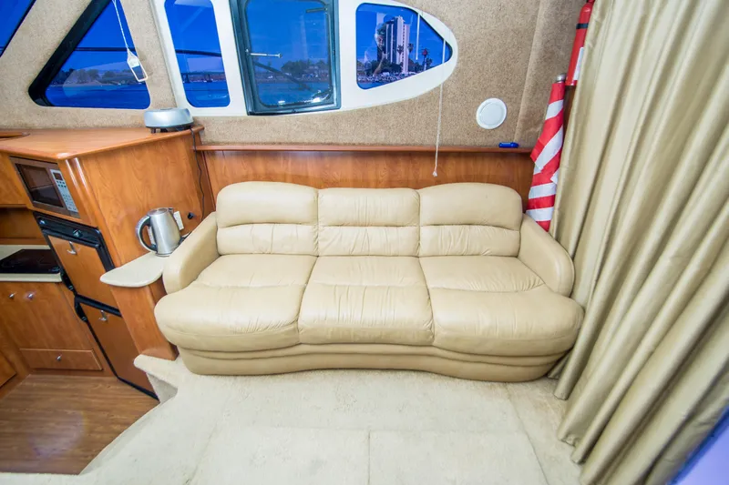 Journeys Edge Yacht Photos Pics Luxurious interior of 2007 Silverton 36 Convertible yacht with beige leather sofa.