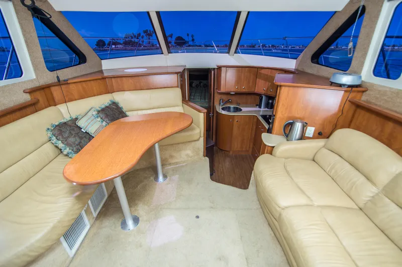 Journeys Edge Yacht Photos Pics Interior of 2007 Silverton 36 Convertible yacht with beige seating and wooden cabinetry.
