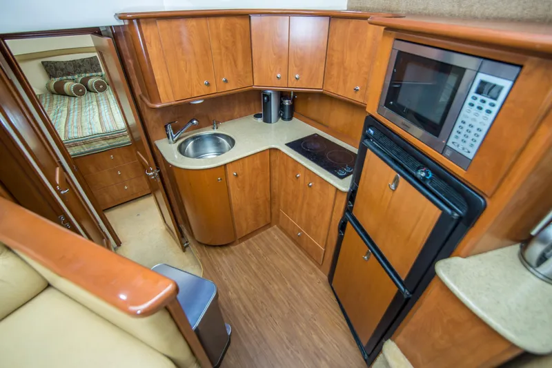 Journeys Edge Yacht Photos Pics 2007 Silverton 36 Convertible yacht kitchen with wood cabinetry, sink, stove, microwave, and fridge.
