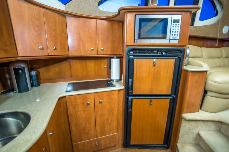 Journeys Edge Yacht Photos Pics 2007 Silverton 36 Convertible yacht kitchen with wood cabinets, microwave, and compact fridge.