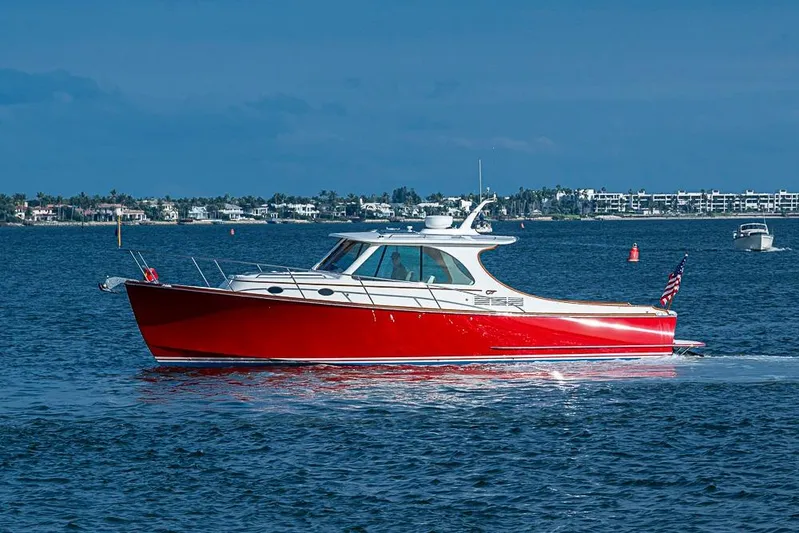 Comin' In Hot Yacht Photos Pics 2016 Hinckley Talaria 34 boat cruising on blue water, with coastal background.