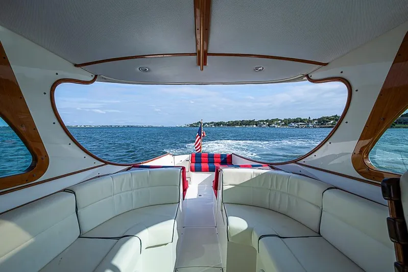 Comin' In Hot Yacht Photos Pics Interior view of 2016 Hinckley Talaria 34 yacht with white seating and ocean backdrop.
