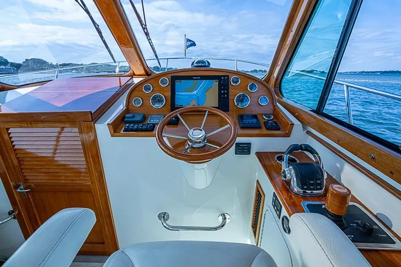Comin' In Hot Yacht Photos Pics 2016 Hinckley Talaria 34 helm with wooden accents and navigation equipment, overlooking the ocean.