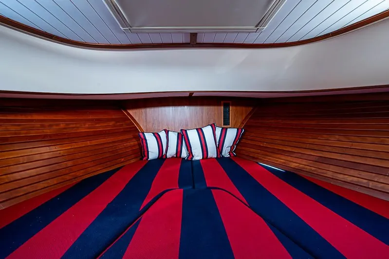 Comin' In Hot Yacht Photos Pics Interior cabin of 2016 Hinckley Talaria 34 with striped bedding and wooden paneling.