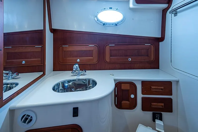 Comin' In Hot Yacht Photos Pics 2016 Hinckley Talaria 34 yacht bathroom with wood accents and stainless steel sink.