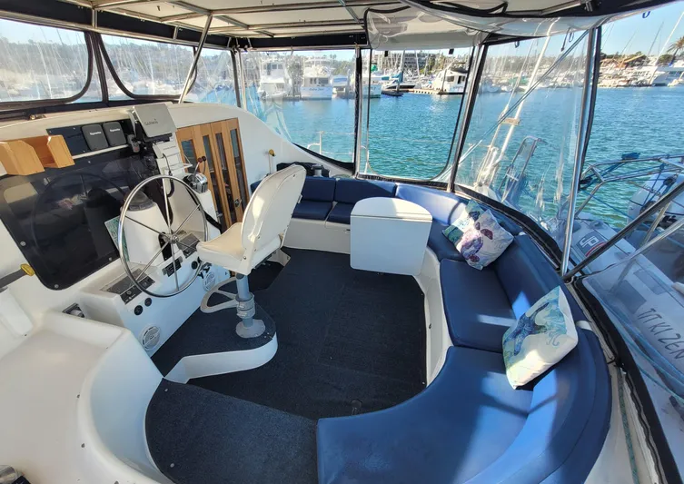 Ki Zen Yacht Photos Pics Interior of 1995 Lagoon TPI 42 yacht with helm, seating, and marina view.