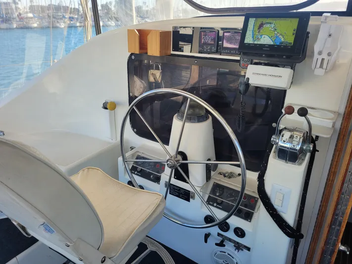 Ki Zen Yacht Photos Pics Cockpit of 1995 Lagoon TPI 42 sailboat with navigation equipment and steering wheel.