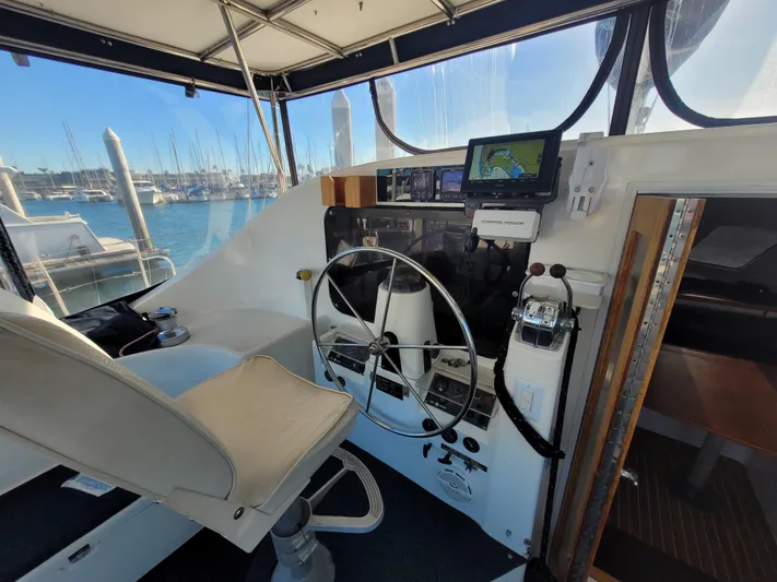 Ki Zen Yacht Photos Pics Interior helm of 1995 Lagoon TPI 42 catamaran with steering wheel and navigation equipment.