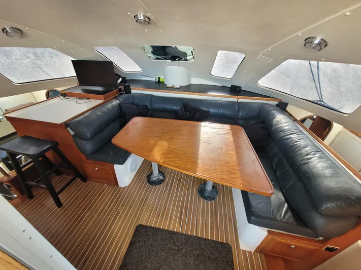 Ki Zen Yacht Photos Pics Interior of 1995 Lagoon TPI 42 yacht with leather seating and wooden table.