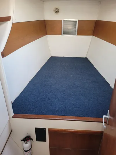 Ki Zen Yacht Photos Pics Interior cabin of 1995 Lagoon TPI 42 with blue carpet and wood accents.