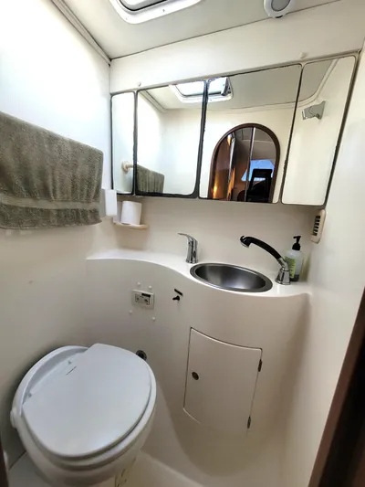 Ki Zen Yacht Photos Pics Compact bathroom in 1995 Lagoon TPI 42 yacht with mirror, sink, and toilet.