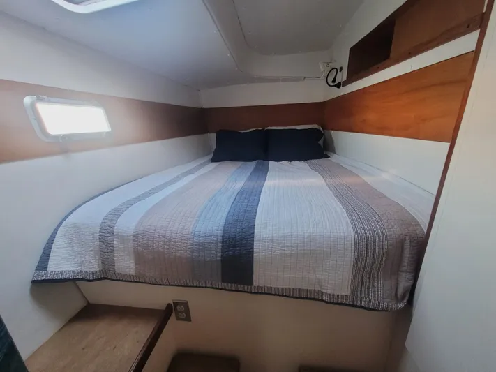 Ki Zen Yacht Photos Pics Cozy cabin interior of 1995 Lagoon TPI 42 sailboat with striped bedding.
