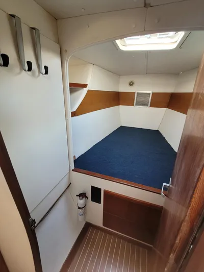 Ki Zen Yacht Photos Pics Interior cabin of 1995 Lagoon TPI 42 sailboat with blue bedding.