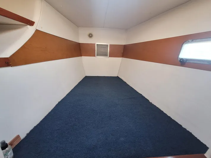 Ki Zen Yacht Photos Pics Interior cabin of 1995 Lagoon TPI 42 with blue carpet and wooden accents.