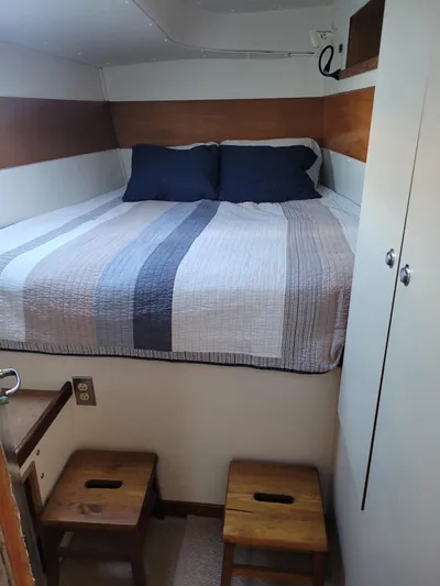 Ki Zen Yacht Photos Pics Cozy cabin interior of 1995 Lagoon TPI 42 with striped bedding and wooden accents.