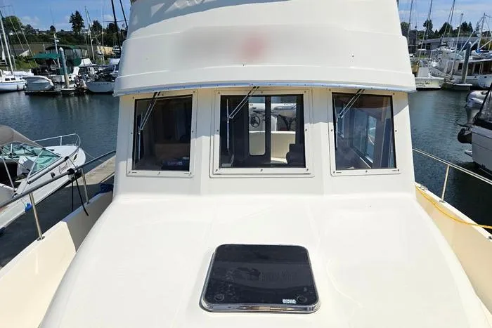  Yacht Photos Pics 2007 Mainship 34 Trawler docked at marina, front view with windows and hatch.