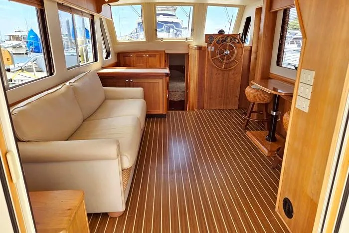  Yacht Photos Pics Interior of 2007 Mainship 34 Trawler with wooden flooring and beige sofa.