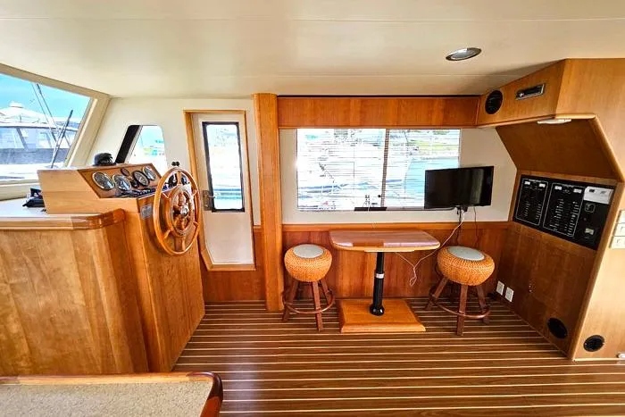  Yacht Photos Pics 2007 Mainship 34 Trawler interior with wooden helm, seating, and TV.