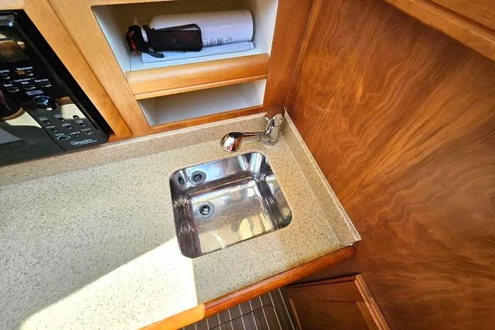  Yacht Photos Pics 2007 Mainship 34 Trawler kitchen sink with wooden cabinetry and countertop.