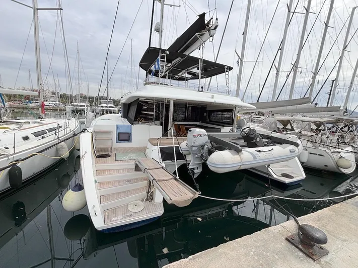Avra Yacht Photos Pics 2014 Lagoon 560 S2 yacht docked with inflatable boat, marina setting.