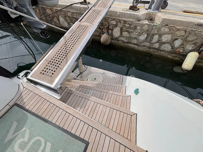 Avra Yacht Photos Pics Wooden deck and gangway of a 2014 Lagoon 560 S2 yacht at a marina.