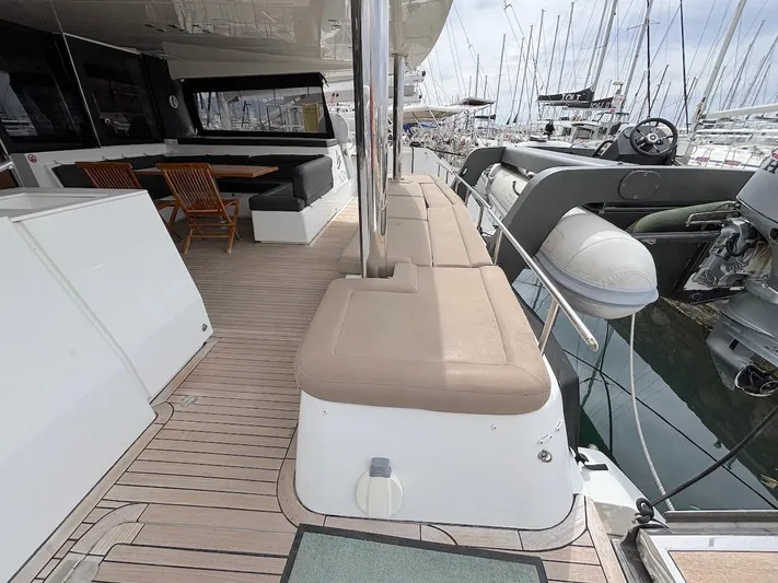 Avra Yacht Photos Pics Luxurious 2014 Lagoon 560 S2 yacht deck with seating and tender in marina.