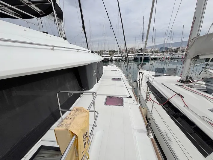 Avra Yacht Photos Pics 2014 Lagoon 560 S2 yacht docked at marina, showcasing sleek deck design and nearby boats.
