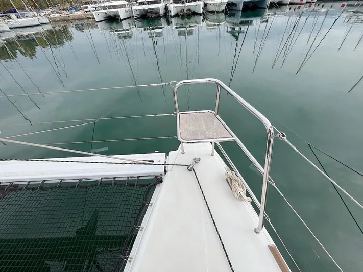 Avra Yacht Photos Pics Bow of 2014 Lagoon 560 S2 catamaran docked in marina, featuring netting and railing.